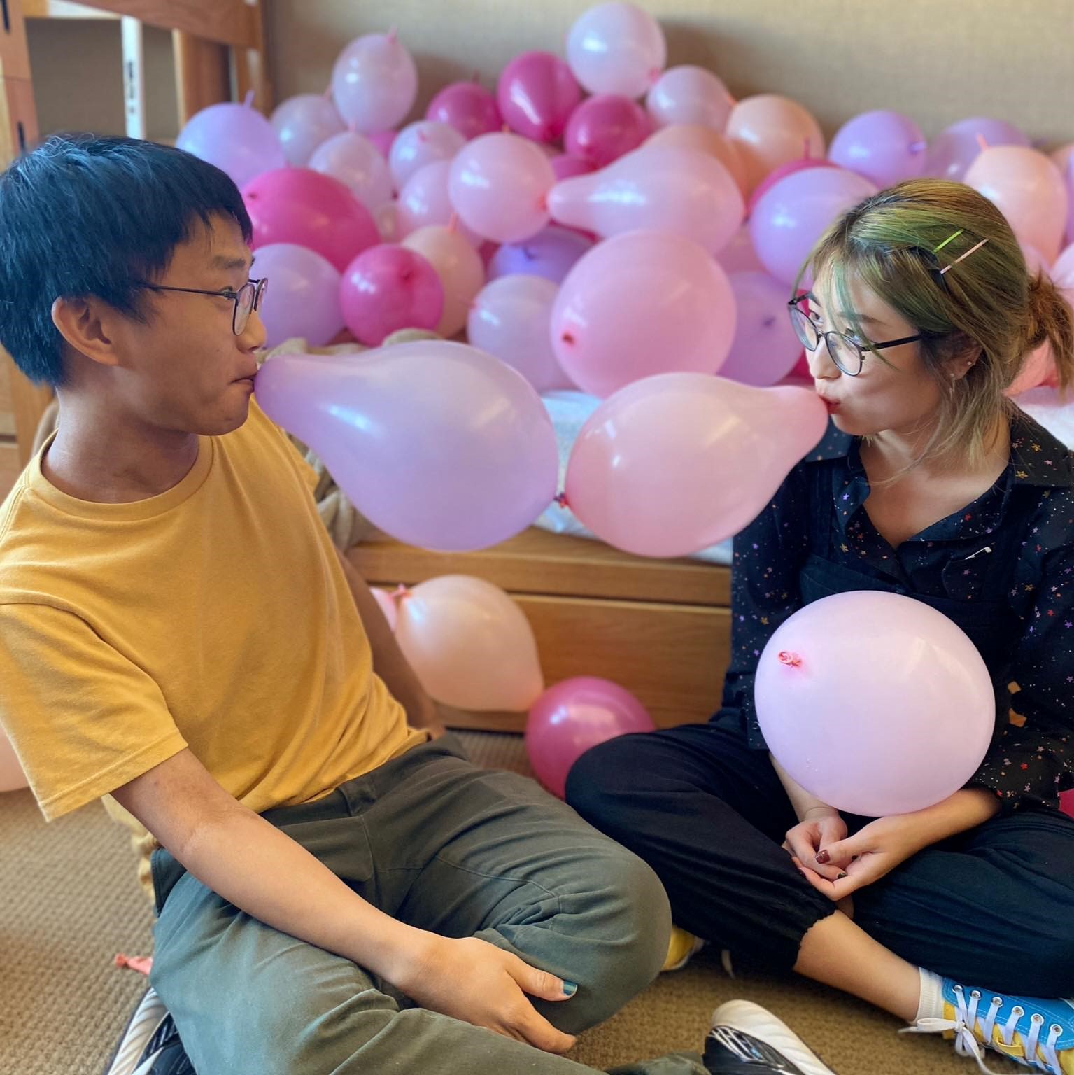 Austin and Helia with connected balloons in their mouths. photo taken by Einar Balan.