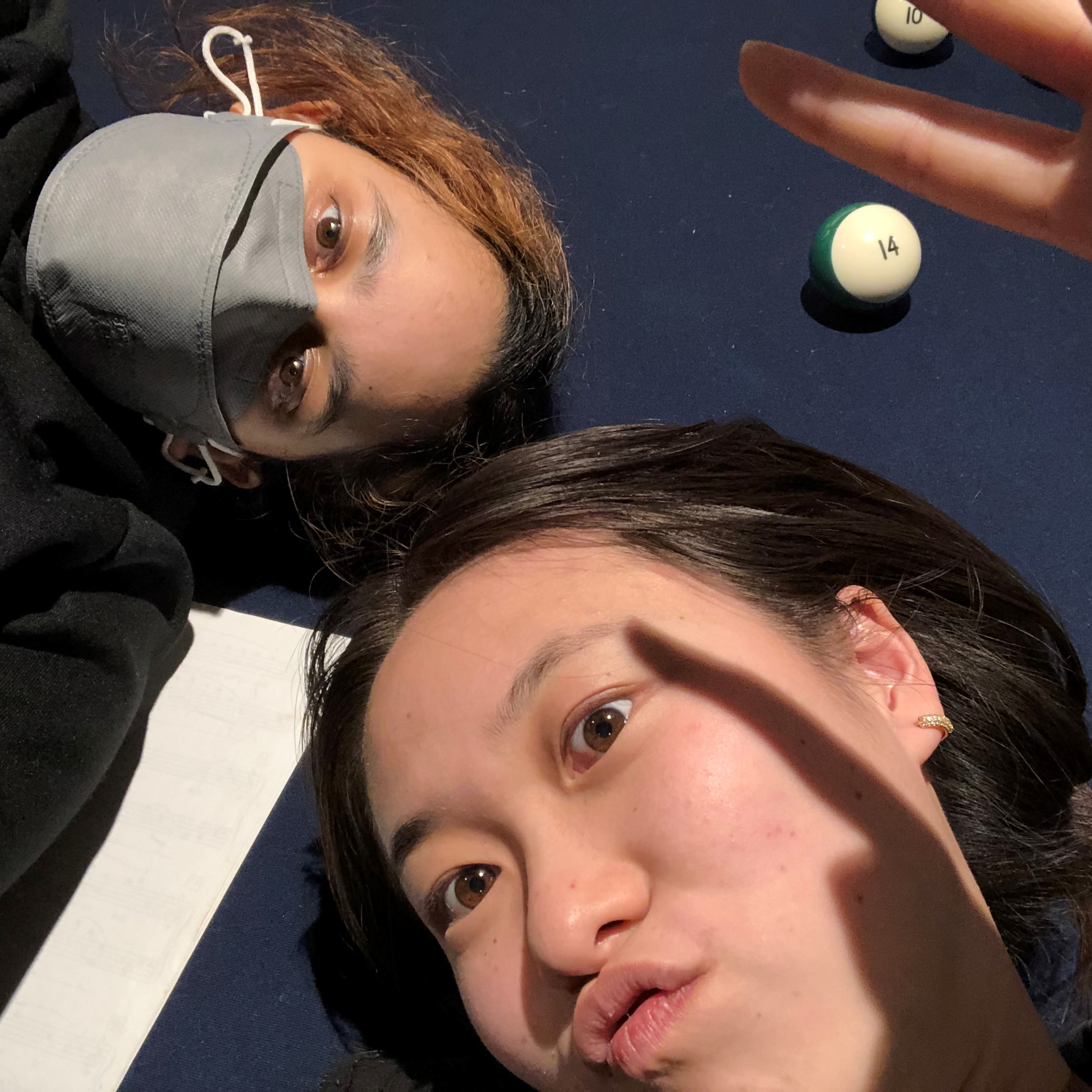 selfie of priya and kelly on top of a pool table